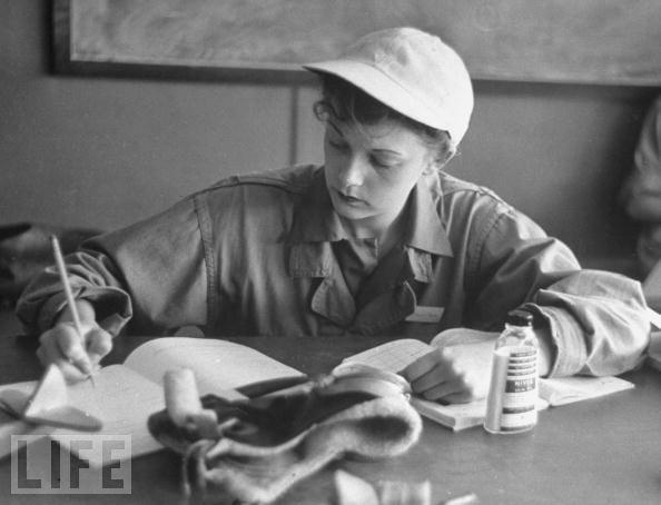 Phyliss Jarman, a pilot trainee in the Women's Flying Training Detachment, wearing her favorite white baseball cap, writes up a report in her workbook during training to fly for the Women's Auxilary Ferrying Squadron at Avenger Field in Texas.
