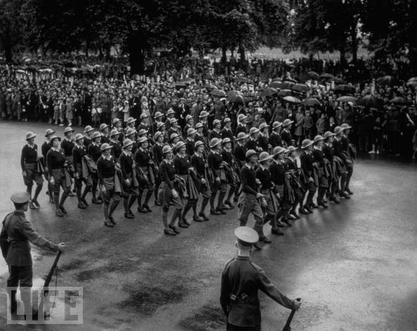 "Land Girls," volunteers in the Women's Land Service, who will replace male farm workers sent to battle, are among the 20,000 volunteers marching before King George VI in this 1939 parade in Hyde Park, London.