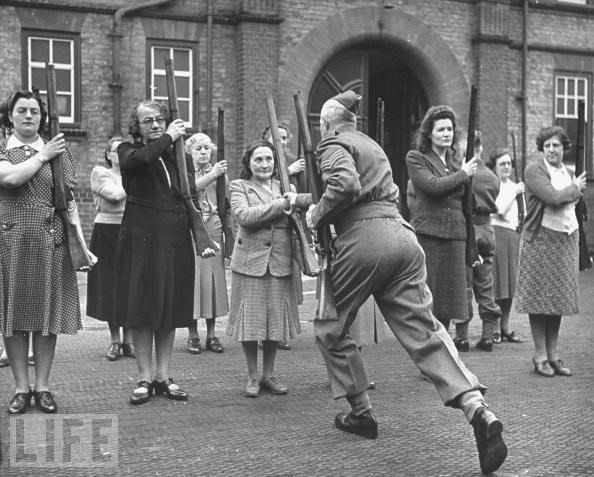 A sergeant drills civilian women, members of the Women's Home Defence Corps, in the use of rifles.