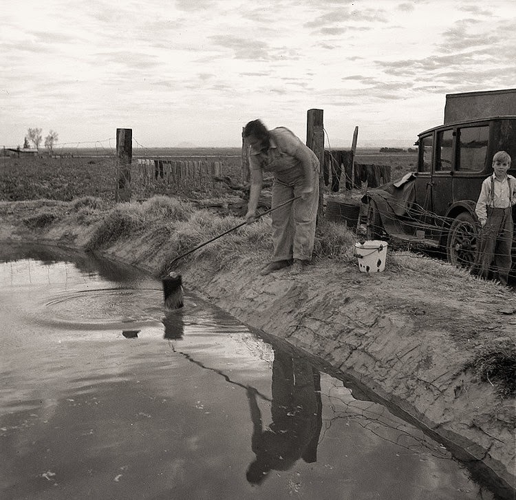 Water supply: an open settling basin from the irrigation ditch in a California squatter camp near Calipatria
