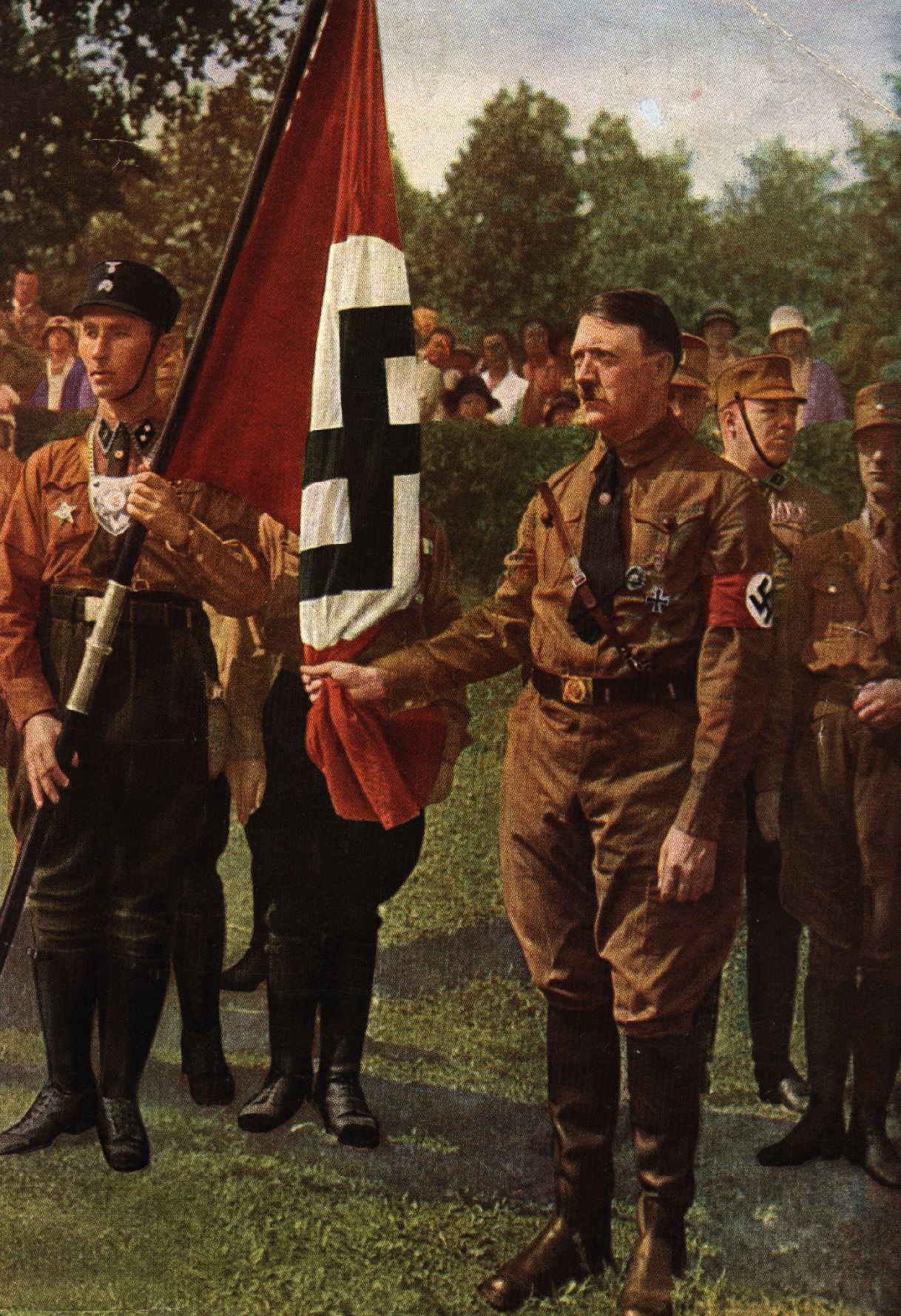 Adolf Hitler holds the “Bloodied Standard” of the Nazi party at a memorial ceremony for the failed uprising of 9th November 1923