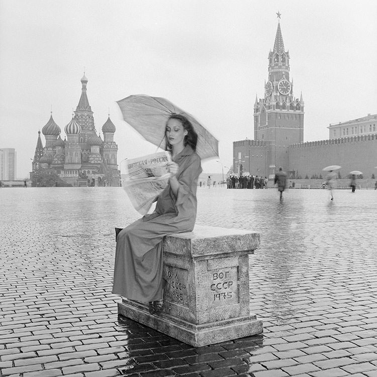 Jerry Hall reading a paper in Red Square wearing Yves Saint Laurent Rive Gauche, 1976