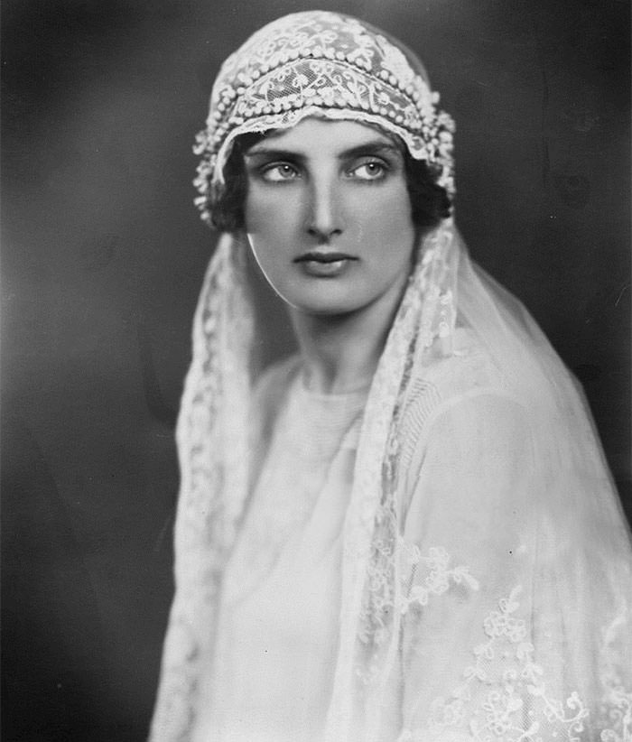 A young bride wearing a train decorated with lace, 1927.