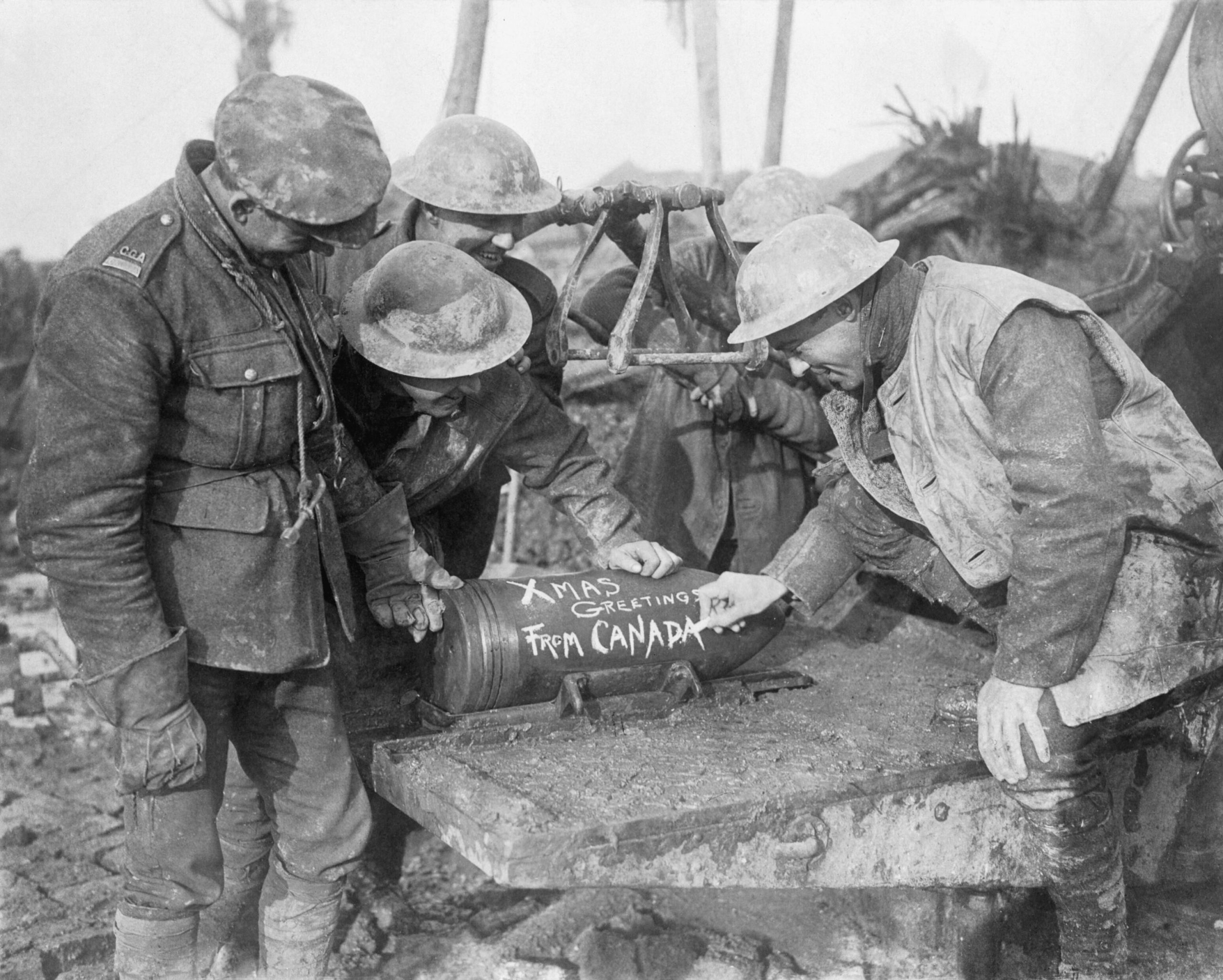 Canadian artillerymen with seasonal messages on an artillery shell during the Battle of the Somme.