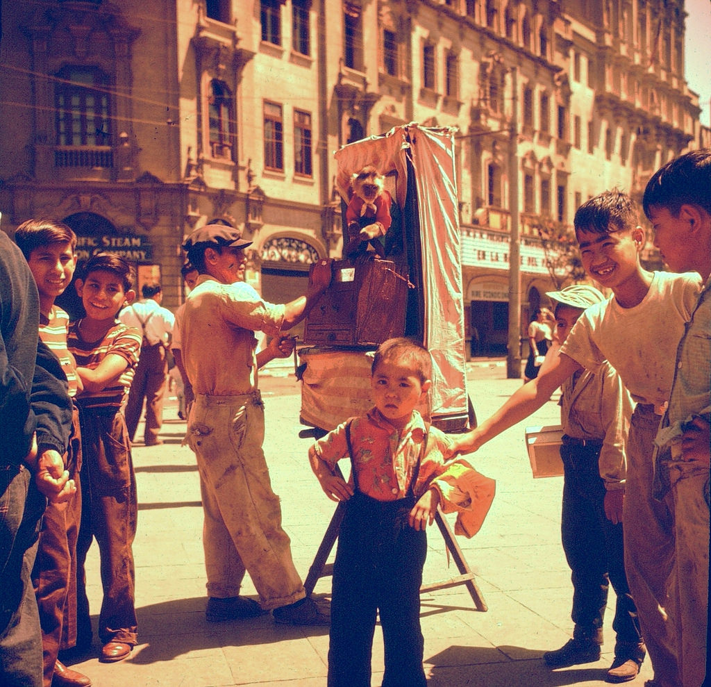 Organ grinder with monkey and kids, Lima, Peru, 1960