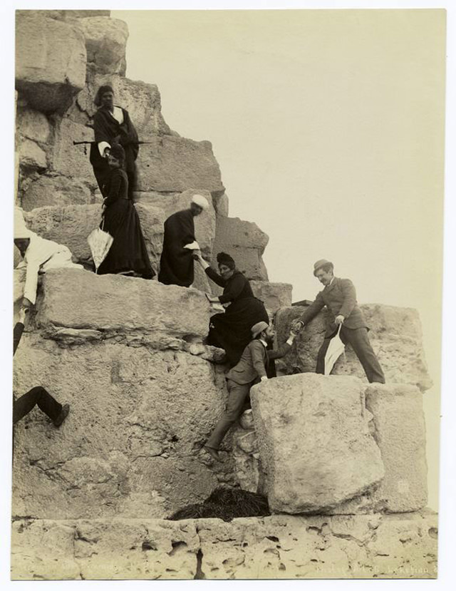 Tourists climbing the pyramids