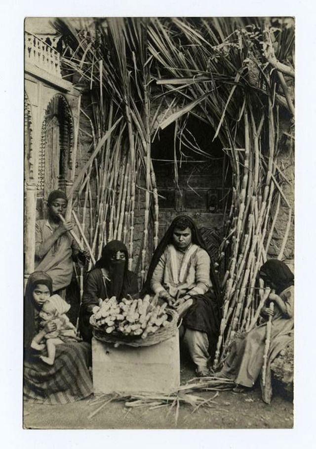 Women and children preparing sugar cane