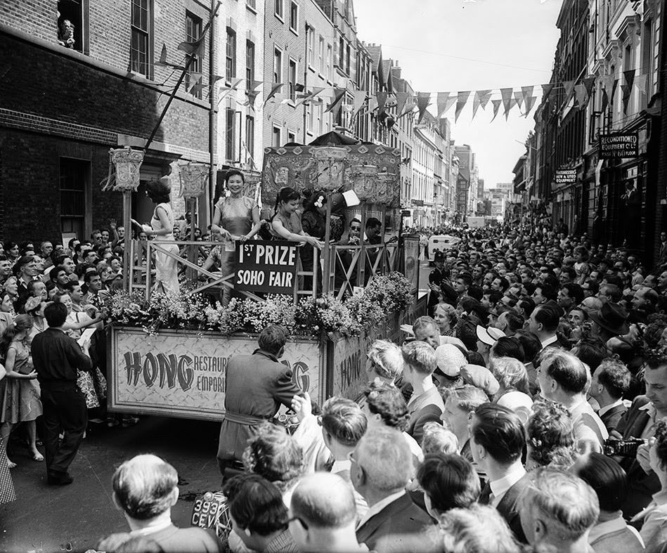 The prize-winning float parades through the streets upon the opening of the Soho Fair, 1955