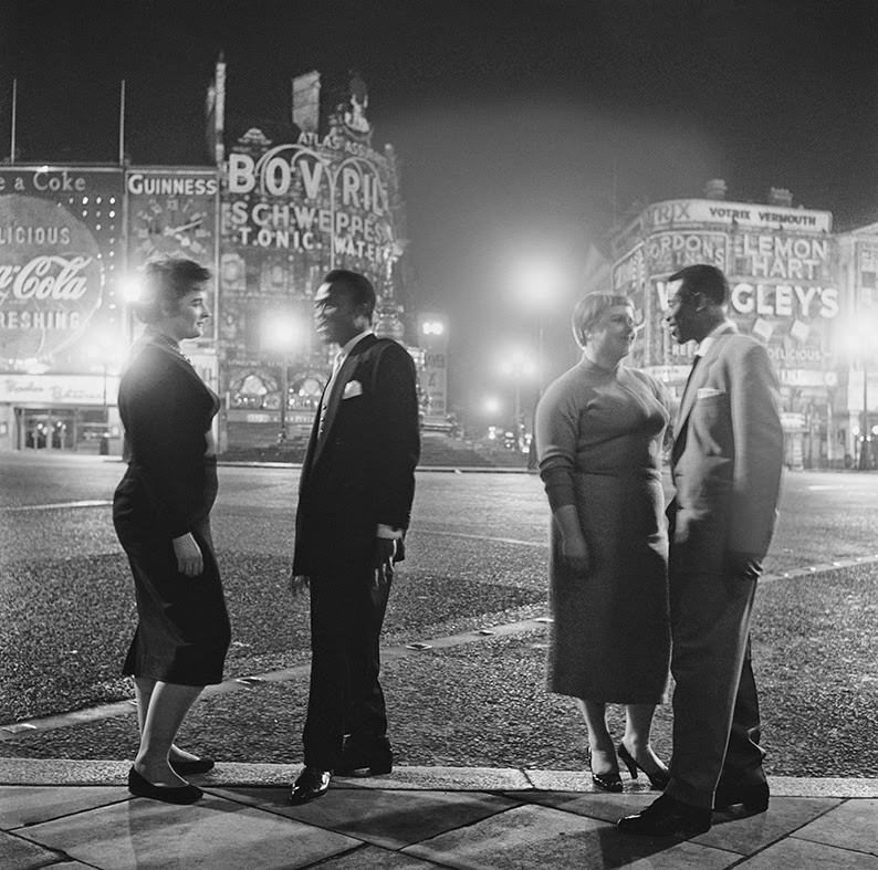 US troops and their girlfriends say goodbye in Piccadilly Circus after leaving the Club Americana, a Saturday night jazz club open from midnight until 7am, 1955