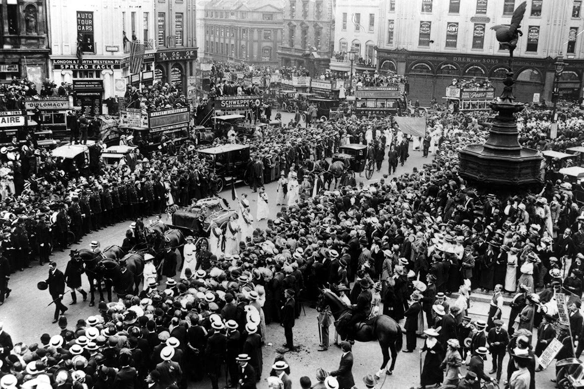 Crowds watch the cortege of suffragette Emily Davison, who was killed by the King's horse at the Derby, passing Eros at Piccadilly Circus, 1913