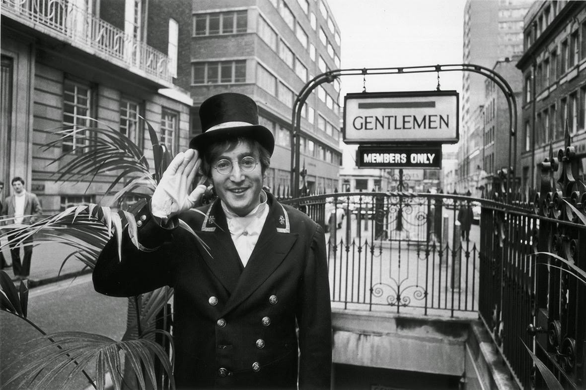 John Lennon, dressed as a Public Lavatory Commissionaire during the filming of the 'Not Only...But Also' Christmas Special, starring Peter Cook and Dudley Moore, stands outside a public convenience on Broadwick Street, 1966