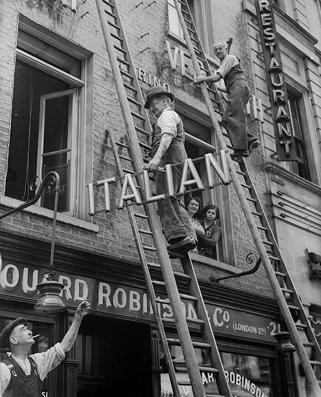 A shopkeeper removes the word 'Italian' from the sign above his restaurant in Soho, after anti-Italian riots throughout Britain, 1940
