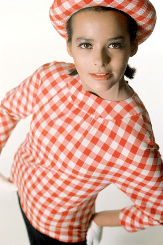 Model wearing red and white checked blouse over navy shift, 1964