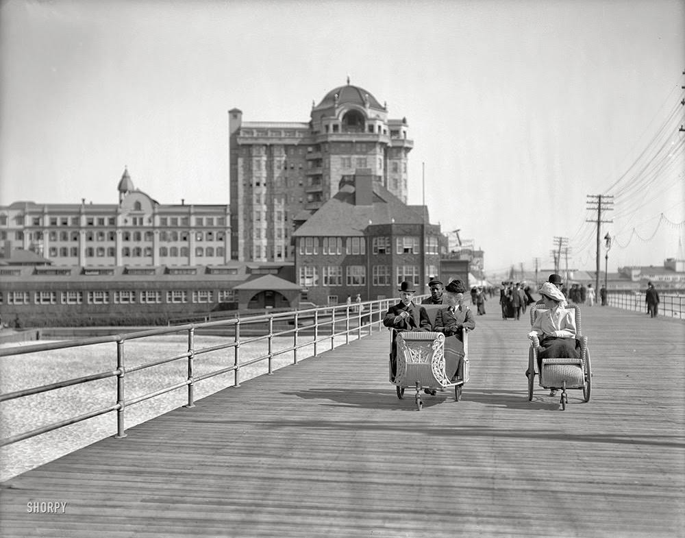 The Jersey shore circa 1906. Rolling chairs on the Boardwalk, Atlantic City. Hotel Traymore in the background.