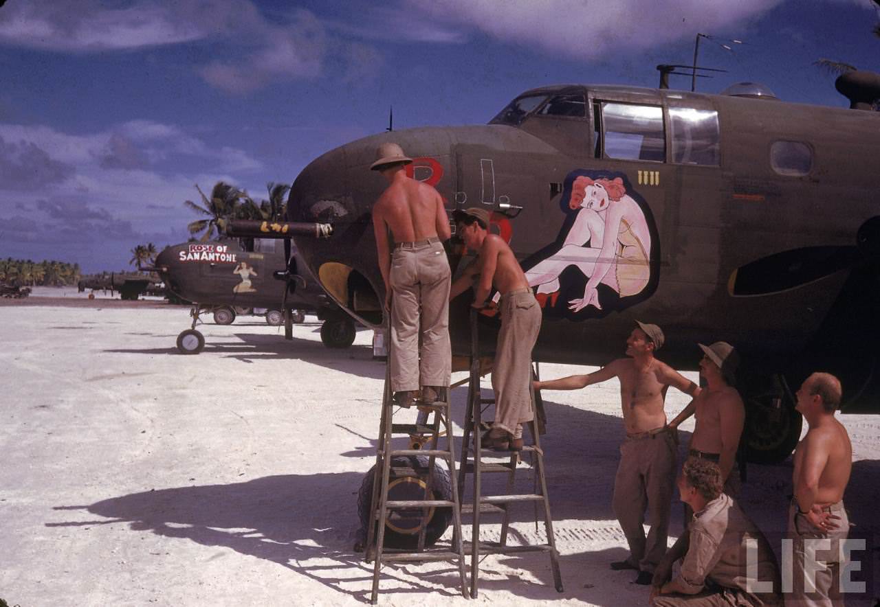 American ground crew doing maintenance work on a bomber during WWII.