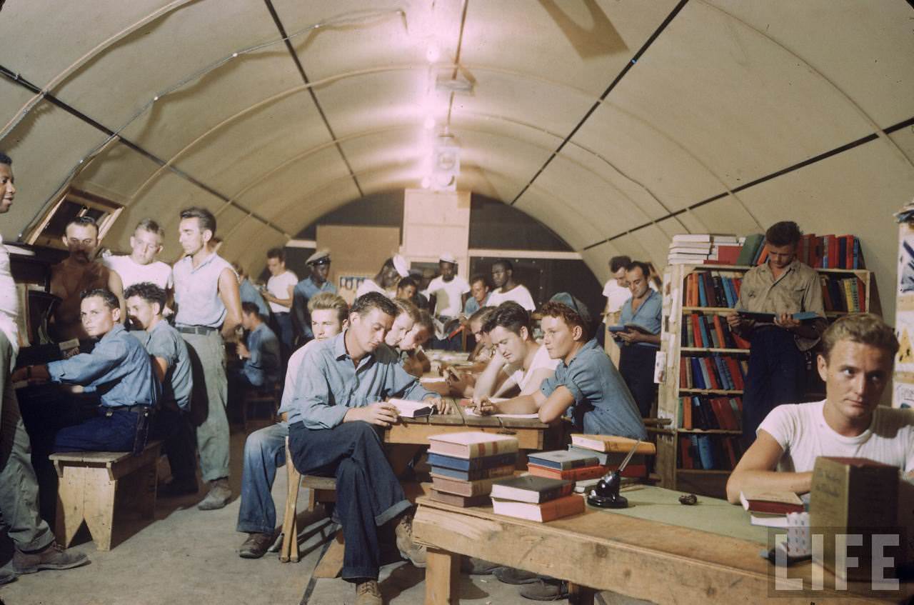 American servicemen relaxing in a quonset hut being used as a library on an island base during WWII.