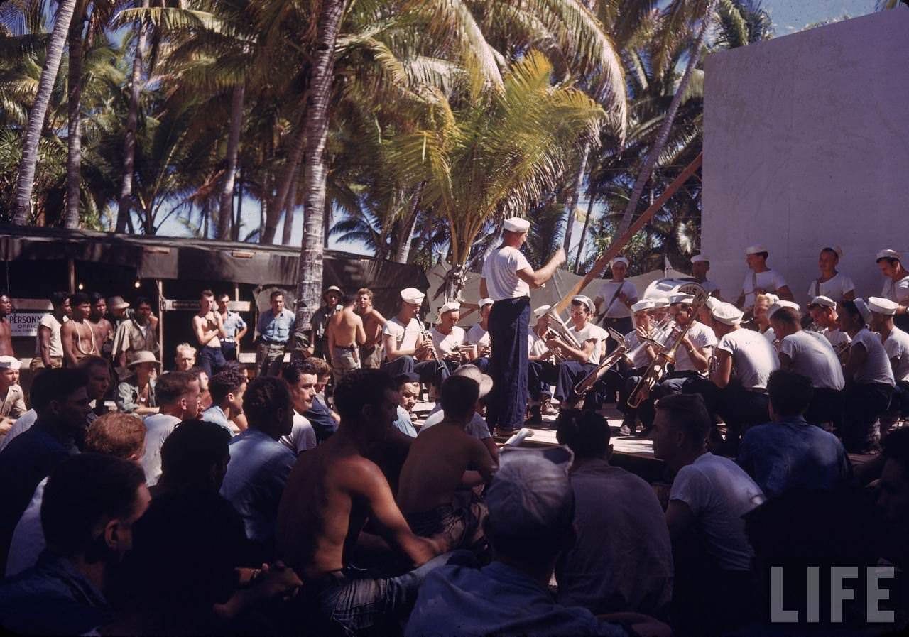 US Navy band playing small concert for servicemen and curious locals during WWII.