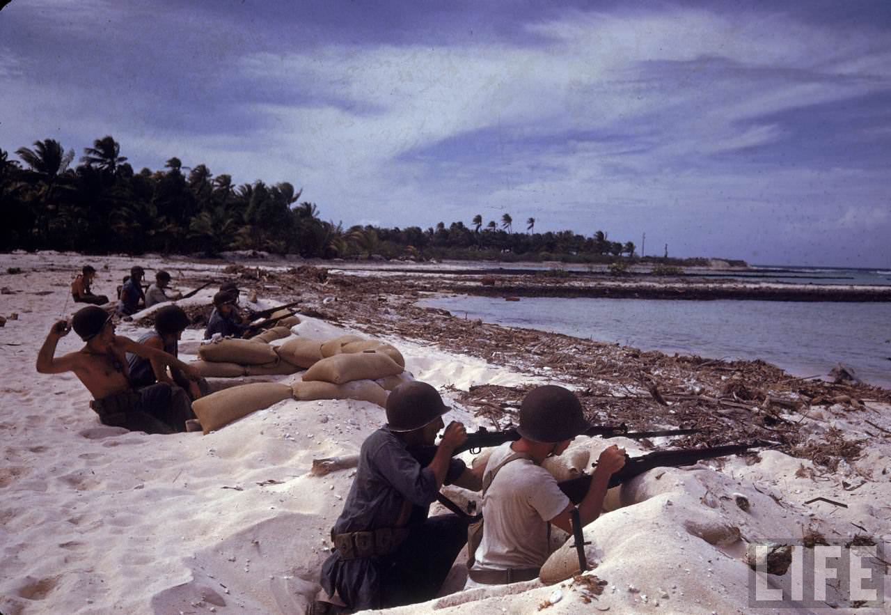 American soldiers manning gun nests protecting the island shore during WWII.