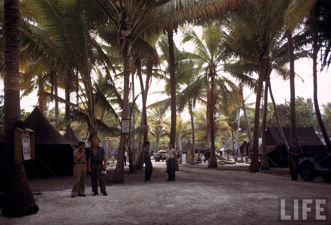 Natives carrying boxes at an American island base during WWII.