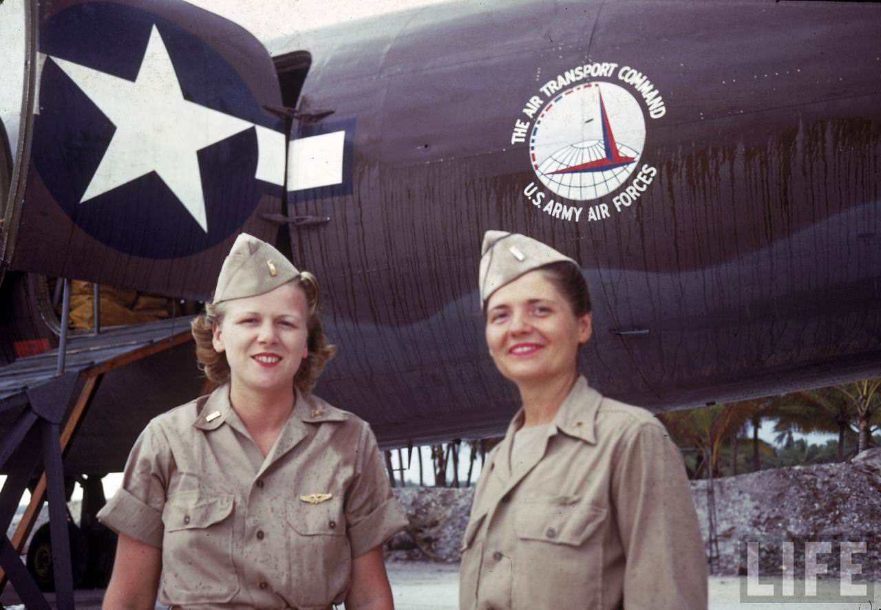 Pair of servicewomen in front of an Army Air Corps. Air Transport Command plane.