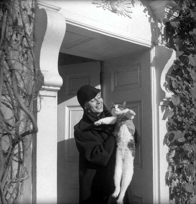 Greta Garbo with Cecil Beaton’s cat at his home, Reddish House, in Broadchalke, England, 1951