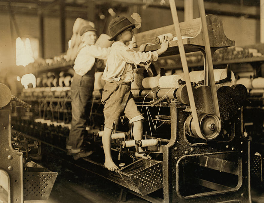 Some boys were so small they had to climb up on the spinning frame to mend the broken threads and put back the empty bobbins. Location: Macon, Georgia