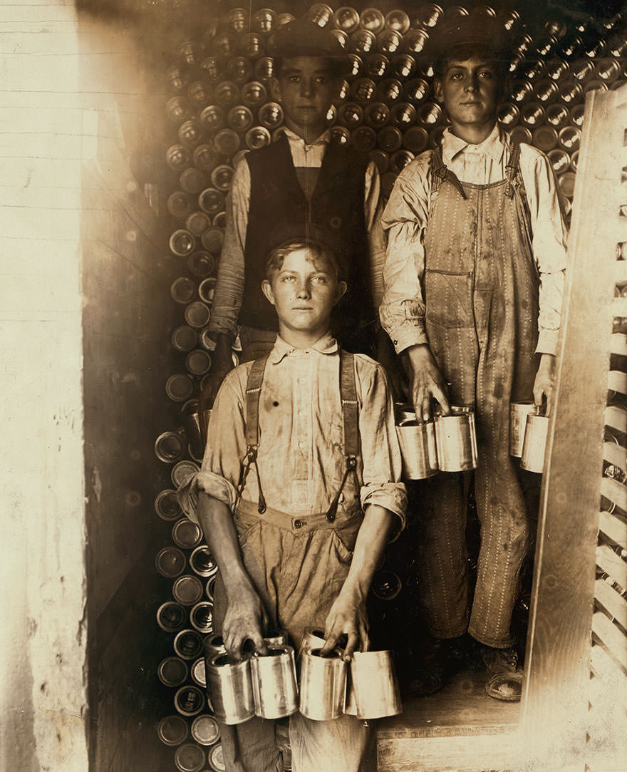 Boys working in a cannery, Indianapolis, unloading freight cars full of new tomato cans. Location: Indianapolis, Indiana