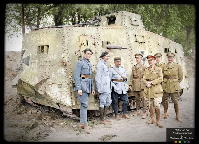 French and British soldiers standing around a German A7V tank captured at Villers-Brettoneux, May 1918