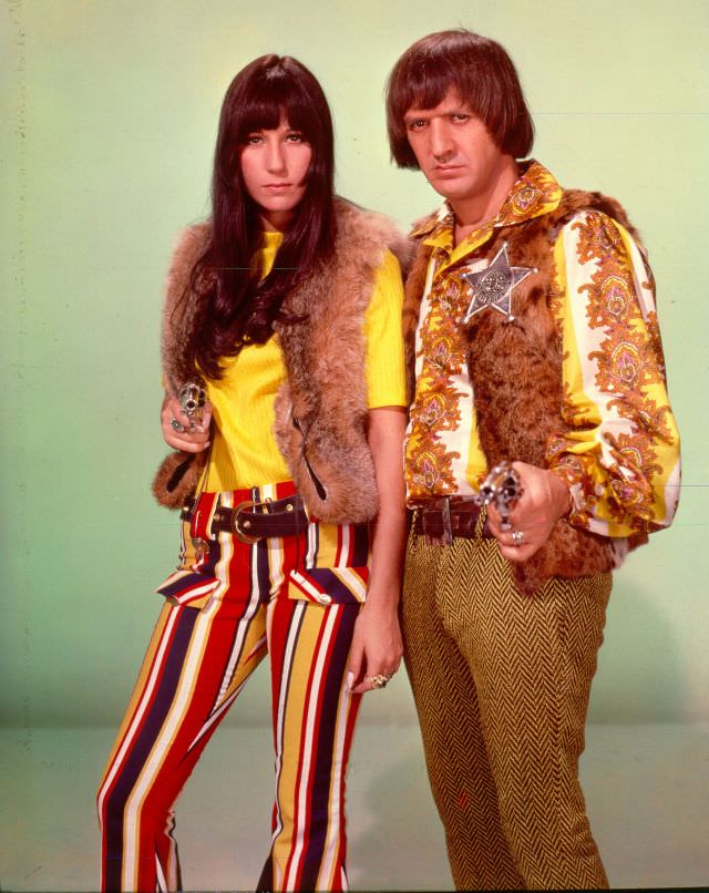 Sonny Bono and Cher point guns toward the camera as they pose for a portrait. Photo by Michael Ochs Archives, 1970