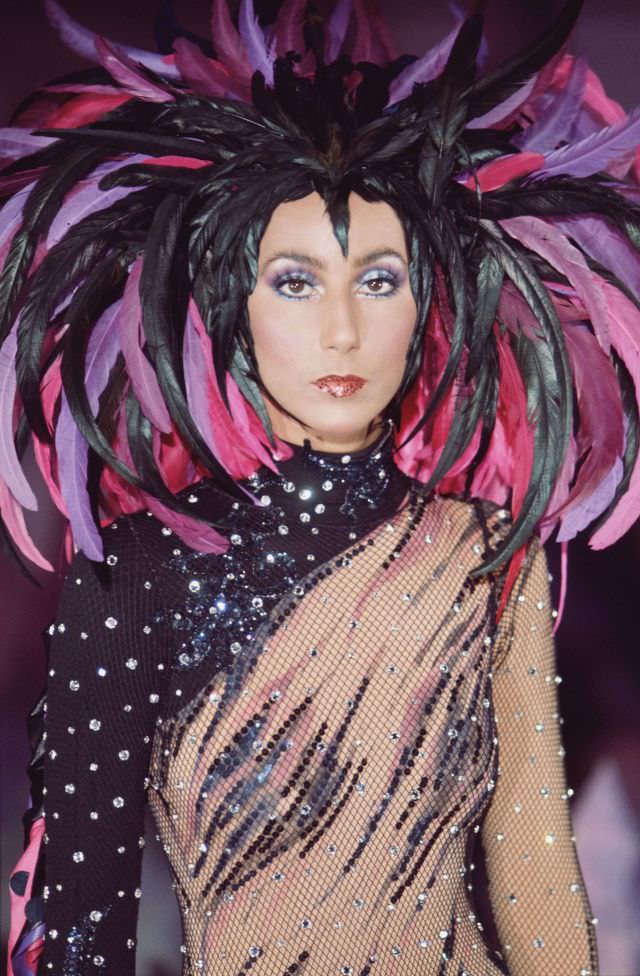 Promotional portrait of Cher in a semi-transparent outfit with a feathered headdress for the television variety show 'The Sonny and Cher Comedy Hour, 1972