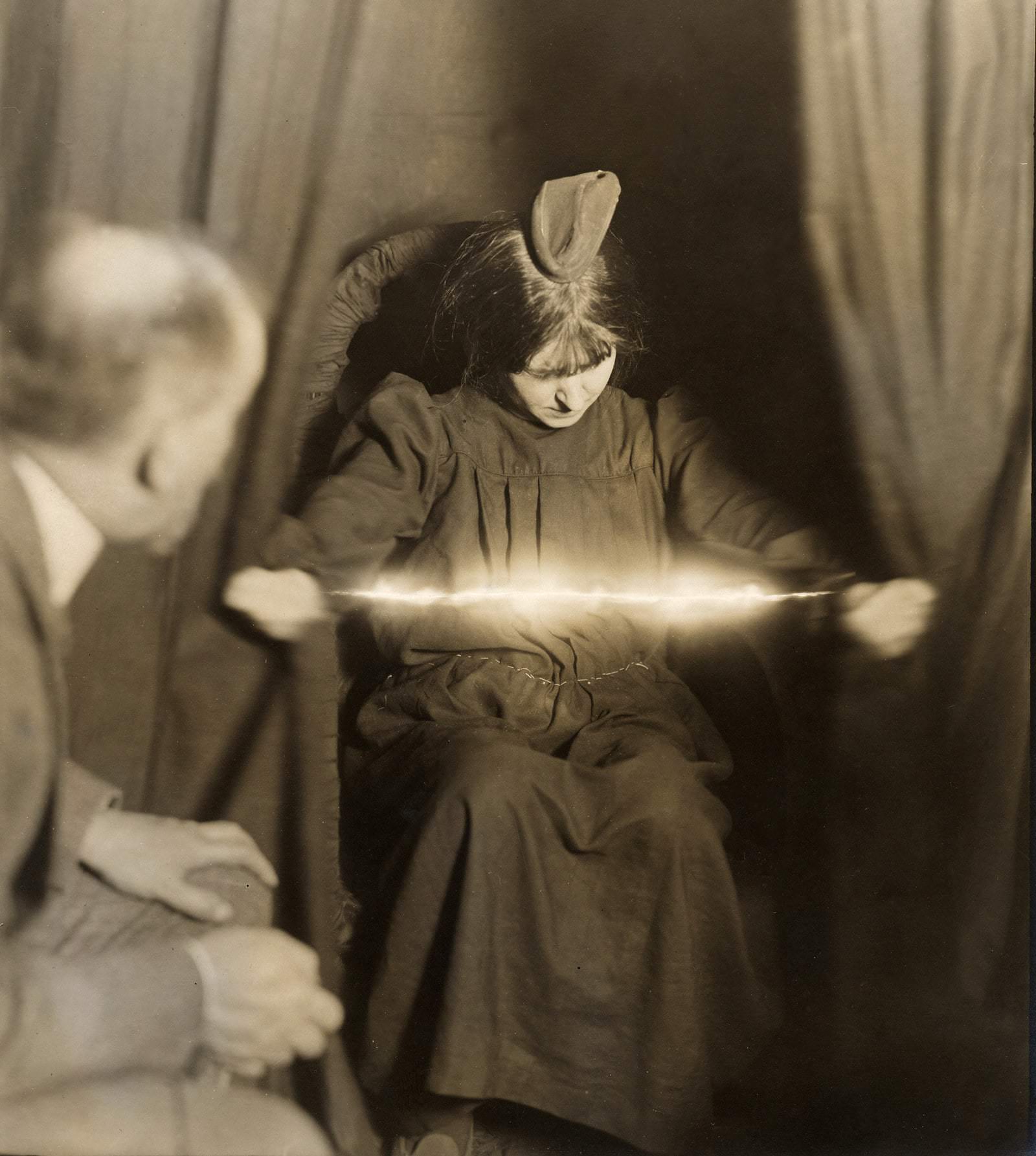 The medium Eva C. forcing a luminous apparition between her hands on May 17, 1912