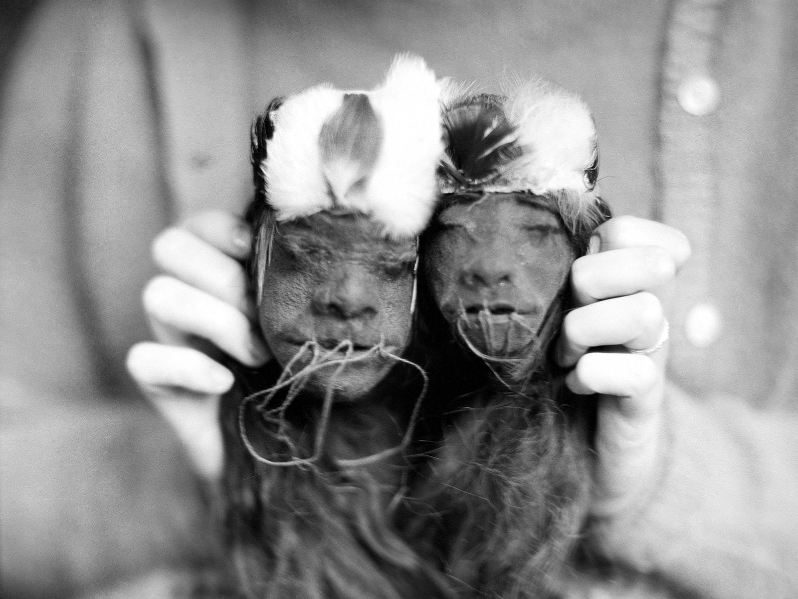 A 19th-century anthropologist showing off his pair of shrunken heads from Ecuador
