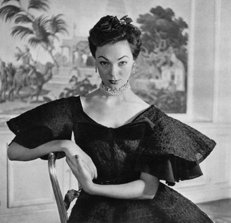Ivy Nicholson in crimped lace cocktail dress with very full skirt, velvet bow at the neckline, by Jacques Fath, 1951