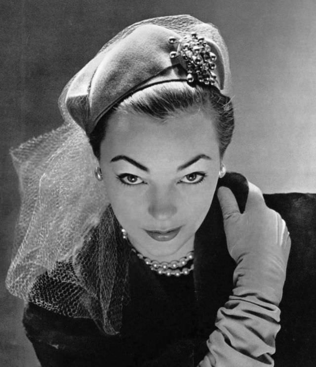 Ivy Nicholson in green jersey hat decorated with net and jeweled pin by Jane Blanchot, 1951