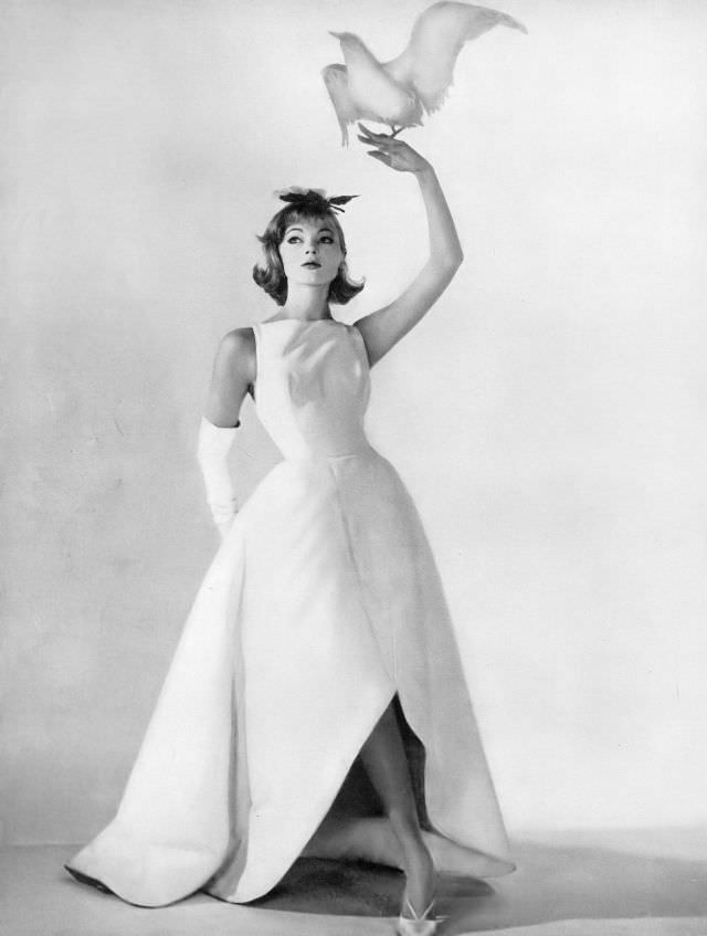 Ivy Nicholson in beautiful evening dress of stiff white cotton ottoman with great petals of skirt that curve up in front and down in back, Harper's Bazaar, March 1958