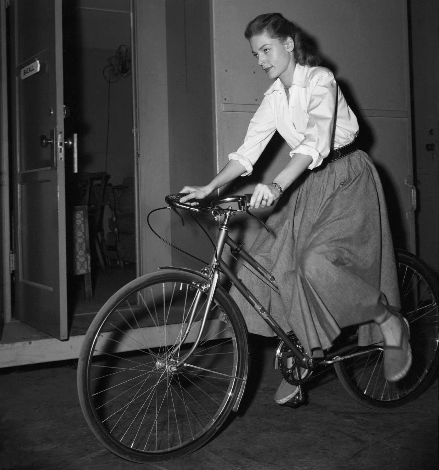 Only she could ably ride a bike in a full skirt, 1948.