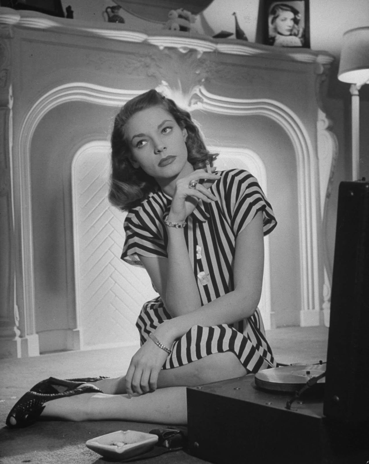 In 1945, she showed off a customary combination: striped tailored dress, smart wedges, and a cigarette.