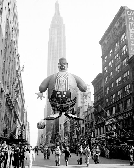 Empire State Building forms a background for this helium-filled clown floating along 34th Street in Macy Parade in 1945.