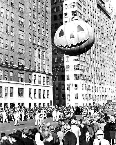 Watchers lean from windows in 1945 as a mammoth pumpkin passes by in the Macy's Thanksgiving Day Parade.