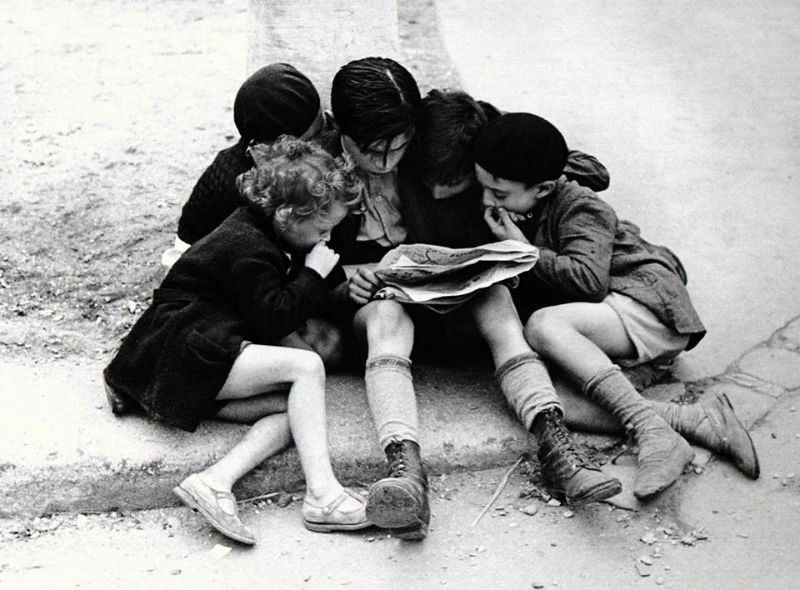 Children reading newspaper, Paris, 1936