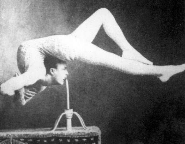 Circus contortionist balancing with his teeth, 1900s