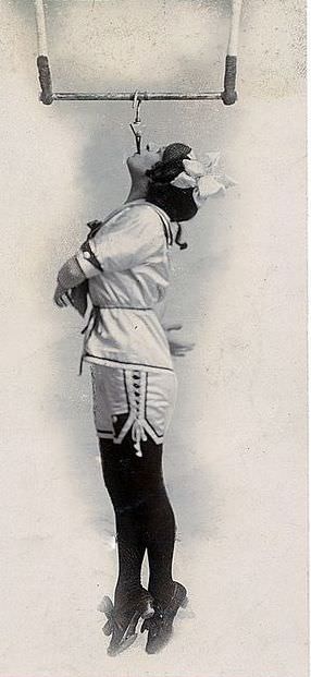 Edwardian circus performer Pansy Chinery with dangling in the air by her teeth, 1916