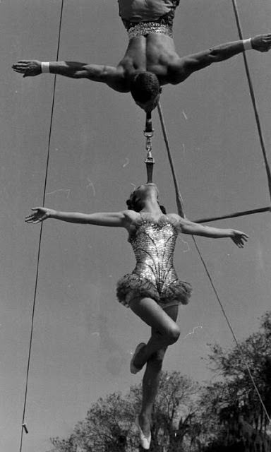 Two acrobats doing a aerial balance by their teeth