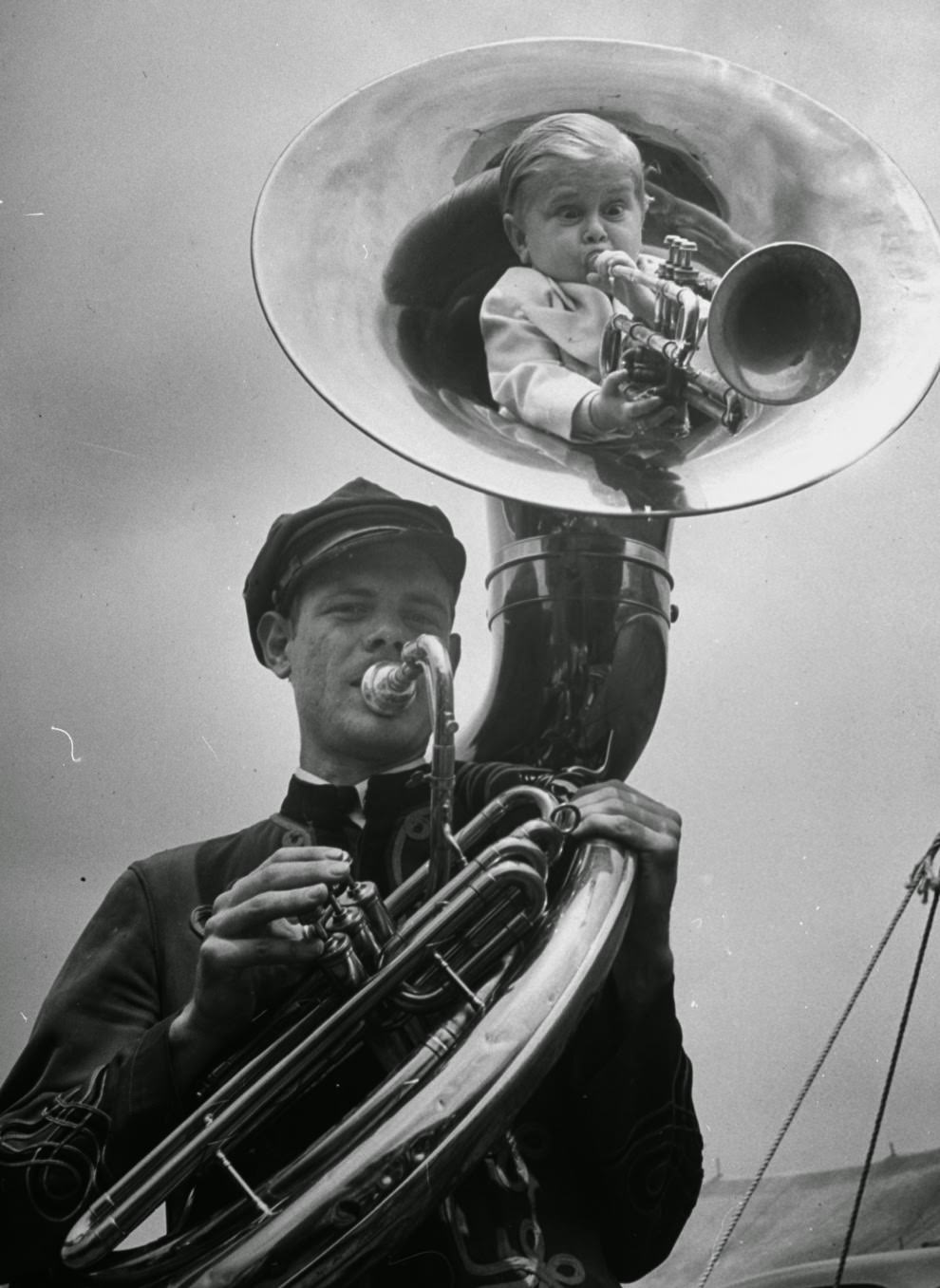 Czech showman Baron Richard Nowak, 19, stands 21 inches high & weighs 17 lbs., blowing on a trumpet as he nestles inside tuba player of the Hamid-Morton Circus, 1940