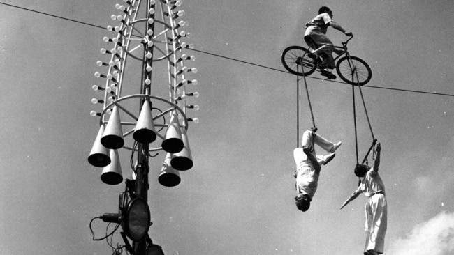 Spanish high wire cycling act The Mestelrich Trio, performing high above Battersea Pleasure Gardens, London.