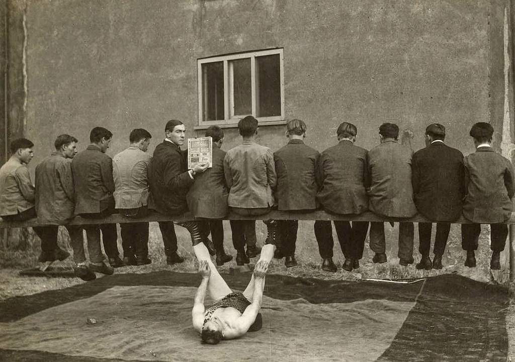 A strong man carrying 12 men on his legs in a circus perofrmance