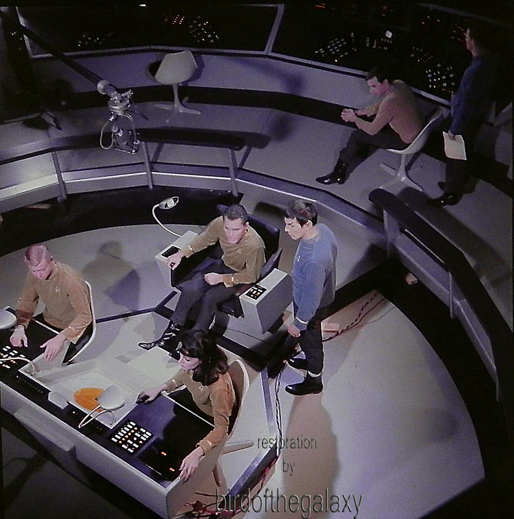 Majel Barrett, Leonard Nimoy, and Jeffrey Hunter are visible in the shot, but in addition one can see both a sound boom and wires that presumably carry the power that is illuminating a number of the controls at the helm and weapons stations.