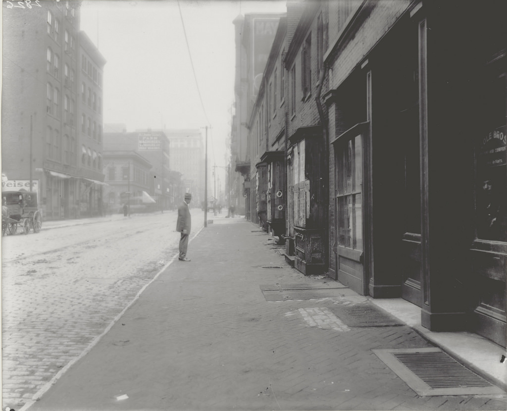 A man peers out of the window at Cole Brothers Lightning Rod Company at 316 S. Seventh Street, ca. 1900s