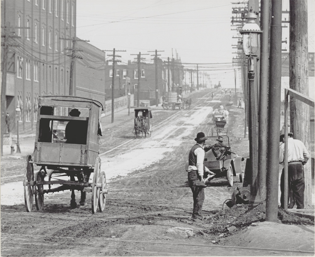 Street workers and carriages on a street in St. Louis, ca. 1900s