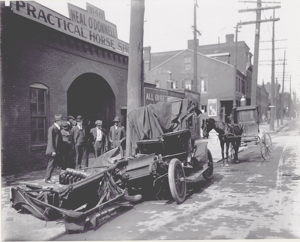 Wrecked car parked outside of Neal O'Donnell's Practical Horse Shoeing shop at 3148 Chouteau Avenue, 1906